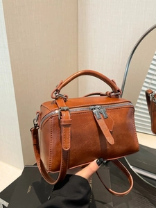 Brown vintage leather crossbody bag with top handle and silver dual zippers