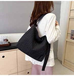 Détail du grand sac cabas noir avec texture plissée et large bandoulière confortable