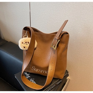 Detail of vintage brown PU leather tote bag with white Summer embroidery and plush charm