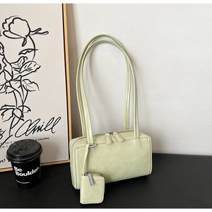 Dettaglio di una borsa minimalista verde chiaro con piccolo portamonete coordinato