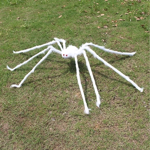 Macro shot of large white plush spider with red eyes for Halloween outdoor yard decoration