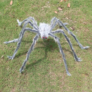 Detailed view of a large black and grey plush spider prop for Halloween on a green lawn