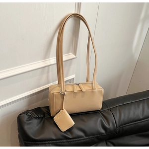 Dettaglio borsa a spalla in pelle verniciata crema con mini pochette abbinata
