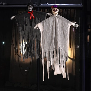 Détail de squelettes d'Halloween suspendus avec capes en gaze et chapeaux haut-de-forme