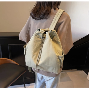 Vue détaillée d'un sac à dos minimaliste vert sauge avec cordon en tissu nylon léger