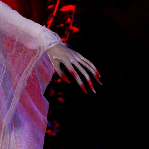 Close-up of Halloween ghost prop showing pale zombie hand with red blood and white mesh