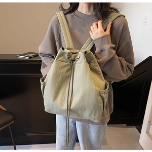 Gros plan du sac à dos vert olive à cordon montrant la texture nylon et la sangle