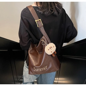 Close-up of large brown PU leather tote bag with Summer embroidery and plush charm