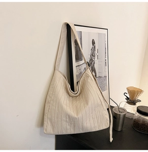 Détail du sac cabas beige plissé en toile avec une texture douce et un style épuré