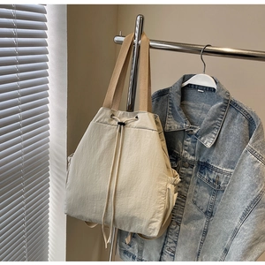 Détail du sac cabas en nylon crème avec cordon de serrage et anses tissées kaki
