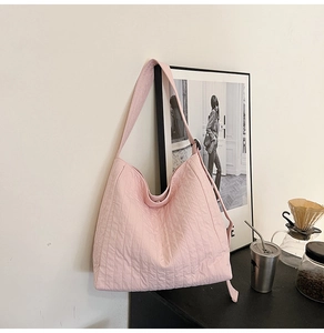 Vue détaillée du sac cabas rose matelassé avec coutures verticales et larges bretelles