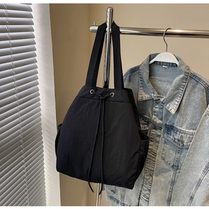 Détail d'un sac à dos en nylon noir à cordon avec tissu imperméable et poches latérales