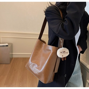 Close-up of brown PU leather shoulder bag featuring Summer embroidery and plush pendant