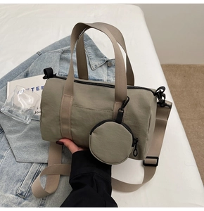 Gros plan d'un sac cylindrique en toile grise avec mini pochette ronde et bandoulière large