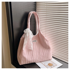 Pink pleated tote bag detail featuring a white lace bow charm and LOVE embroidery