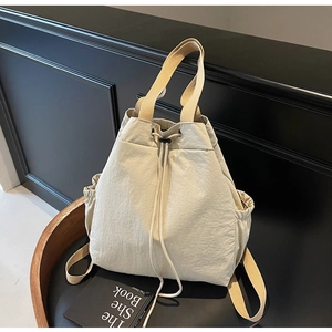 Détail du sac à dos beige à cordon en nylon avec poches latérales et sangles en toile