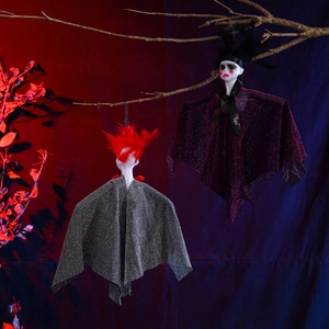 Detail of Halloween hanging ghost dolls with glitter capes on dead tree branches