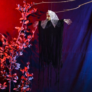 Close-up of Halloween hanging ghost with glowing red eyes and tattered black fabric