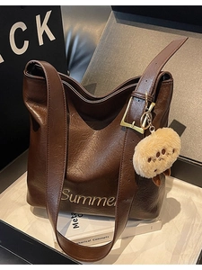 Large dark brown tote bag with vintage texture and plush pendant for daily commute