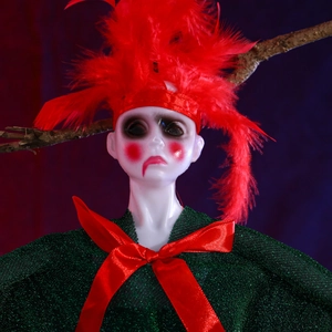 Close-up of Halloween hanging ghost doll with red feathers and green velvet cape decor