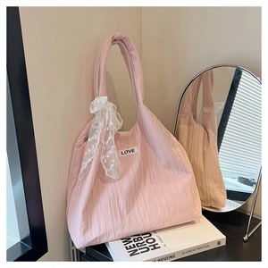 Detailed texture of pink pleated tote bag with LOVE patch and white lace decoration