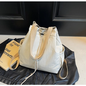 Détail du sac à dos seau à cordon avec texture en nylon et poche latérale