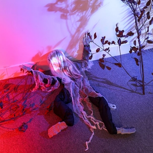 Creepy Halloween climbing ghost with skeletal hands and long white hair on dry branches