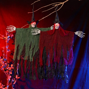 Close-up of Halloween hanging skeletons with glowing red eyes and tattered witch robes