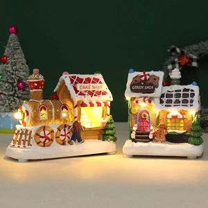 Close-up of lighted resin gingerbread cake shop and candy house Christmas ornaments