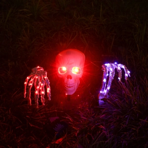 Détail du crâne de squelette LED d'Halloween et des mains d'os avec lumières rouges