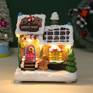 Close-up of a lit LED Christmas candy shop gingerbread house with a cute gingerbread man