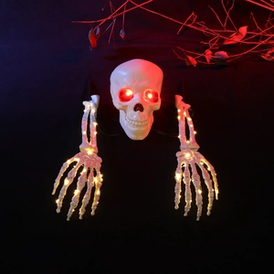 Vue détaillée du crâne lumineux aux yeux rouges et mains squelettes à LED