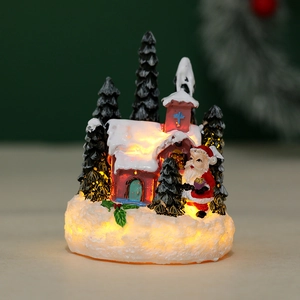 Detail shot of a lighted resin Christmas village house with Santa and snow effect