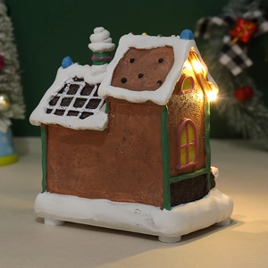 Close-up of LED glowing gingerbread house with snow effects and colorful candy roof decor