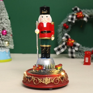 Detalle de cascanueces navideño musical con luces y pequeño tren giratorio decorativo