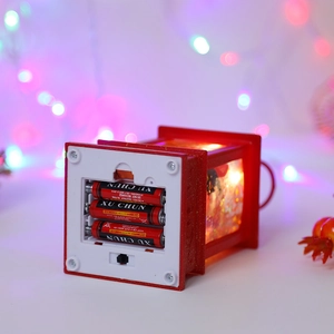 Detail of the battery compartment and base of a red festive lantern with glitter finish