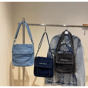 Dettaglio ravvicinato delle borse a tracolla in denim azzurro, indaco e nero su rack