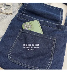 Dettaglio della borsa a tracolla in denim blu scuro con tasca anteriore a patta per smartphone