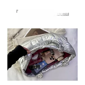 Interior view showing the large capacity and wine red lining of this quilted metallic tote bag