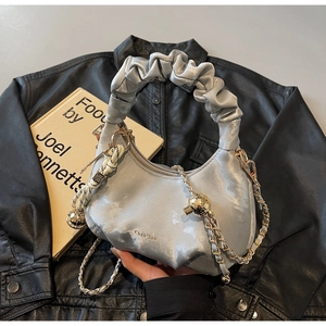 Detail of silver metallic crescent bag with ruched handle and golden chain strap