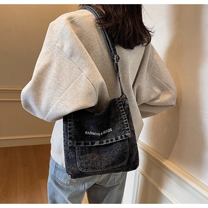 Dettaglio borsa a tracolla in denim grigio vintage con stampa della scritta moda