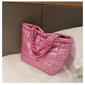 Detail of pink quilted puffer tote bag featuring metallic finish and diamond stitching