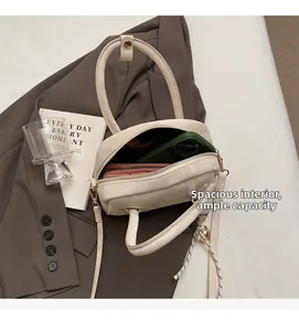 Interior view of cream leather handbag showing capacity for phone and wallet with strap