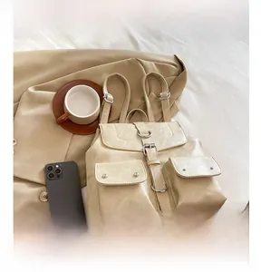 Détails d'un sac à dos beige en cuir avec boucles métalliques et deux poches avant