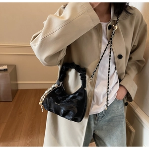 Detail of black pleated cloud bag with chain strap and decorative silk scarf detail
