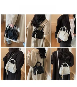 Detail shots of patent leather crossbody bag with top handles and tassel charm
