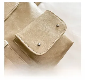 Détail macro du sac à dos en cuir PU beige avec clous argentés et anneau en D métallique