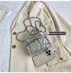 Détail du mini sac matelassé argenté montrant la taille par rapport à l'iPhone 12