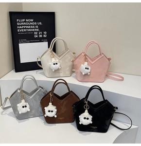 Détail de cinq sacs seaux en cuir marbré de plusieurs couleurs avec breloques en peluche