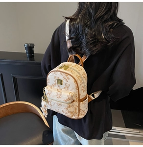 Lifestyle-weergave van de crèmekleurige mini-rugzak met berenprint en teddybeer-hanger
